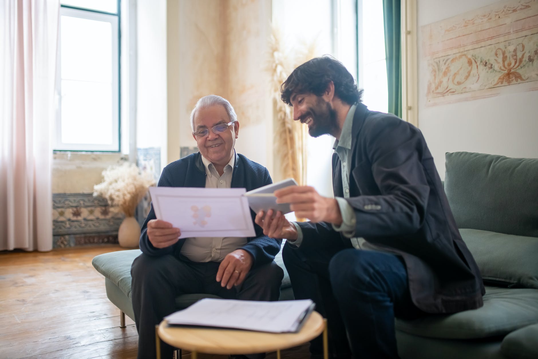 a bearded man sitting on a couch with an elderly client